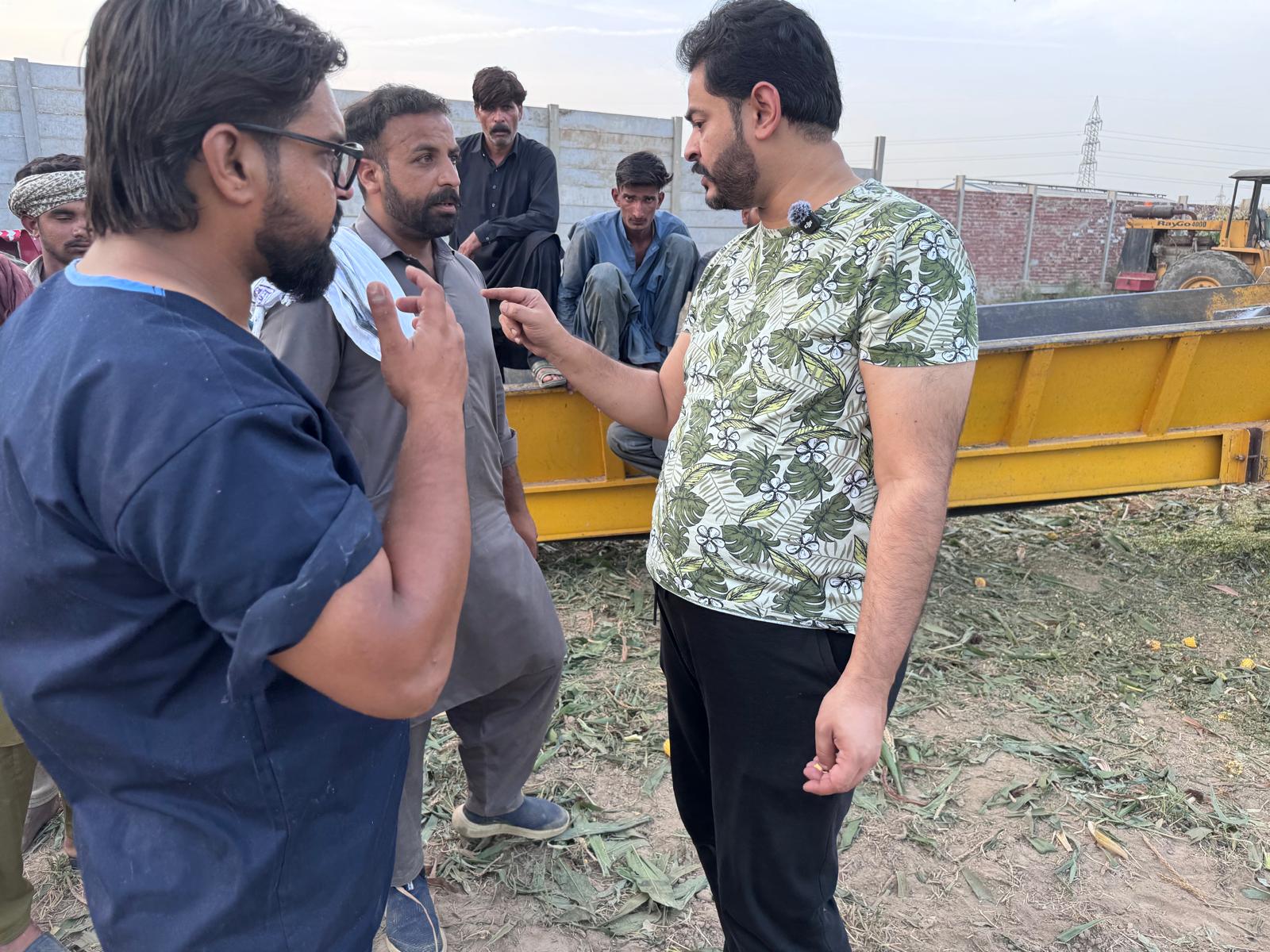 Jafar Hassan in discussion with members of the Gulshan Farms team beside a silage trailer